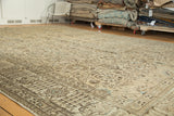 Decorative distressed Tabriz carpet with muted beige, brown, and sky blue floral vine patterns.