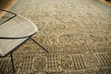 Distressed Tabriz carpet's ornate palmettes, lotus, and willow motifs in beige and blue.