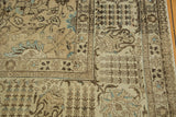Distressed vintage Tabriz carpet corner showcasing intricate palmette vinery and soft blue floral details.