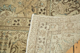 Distressed vintage Tabriz carpet showing hand-knotted reverse and muted beige, blue pile texture.