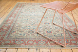 Distressed Kaisary carpet with faded floral and palmette patterns in ivory, red, and blue.