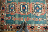 Blue concentric medallion, terra cotta splayed floral border, and abrash on the vintage Oushak rug.