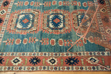 Close-up of vintage Oushak rug's abrashed ocean green field and floral terracotta border.