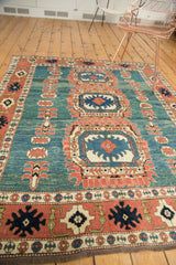 Vintage Oushak rug close-up: abrashed blue-green field, terra cotta floral border, and fringe detail.