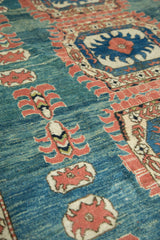 Abrashed blue field featuring splayed floral cross-section motifs and terra cotta main border.