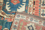 Hand knotted back and fringe of vintage Oushak rug, showing blue, red, ivory motifs.