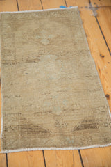 Textured field of a vintage Oushak rug, displaying muted beige, pale sand, and sea foam green abrash.