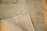 Lifted corner showing hand-knotted foundation and muted beige pile of a Turkish Oushak rug.