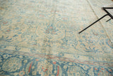 Distressed Persian Meshed carpet with faded ink blue scrolling vinery and lotus flowers.