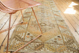 Distressed Oushak rug runner with faded tangerine, ivory, and bronze geometric patterns.