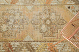 Distressed vintage Oushak rug showing faded tangerine, saffron yellow, and ivory stepped patterns.