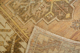 Hand-knotted vintage Oushak rug corner, showcasing distressed texture and woven foundation.