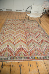 Horizontal blanched blush, ivory, gold, charcoal zig-zag pattern on vintage Jijim rug.