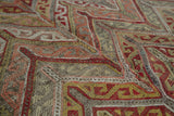 Close-up of vintage Turkish Jijim rug; blanched blush, gold, charcoal geometric chevron pattern.