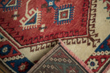 Corner of vintage Dosmealti runner showing cherry red pile, patterned back, and pink-brown fringe.
