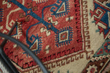 Vintage Dosmealti rug detail: cherry red field, blue stem, geometric motifs, and ivory barber pole border.