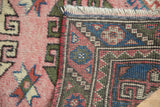 Vintage Dosmealti runner: folded edge reveals barber polled border, blush field, and ivory fringe.
