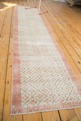 Distressed vintage Oushak runner close-up, blush quatrefoil within charcoal lattice diamonds.