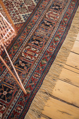 Distressed vintage Joshegan border with intricate brick red, navy floral motifs and natural fringe.