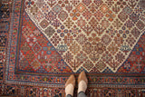 Hand-knotted vintage Joshegan carpet with decorative brick red border and rich field patterns.
