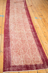 Distressed vintage Konya runner end, wine red border, ivory Moroccan tile pattern, and fringe.
