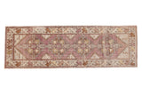 Distressed hand knotted Oushak runner featuring faded eggplant purple medallions and blanched gold patterns, 3x9.