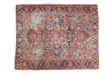Distressed Antique Heriz carpet with large medallion, cherry red, light blue, and faded geometric patterns.