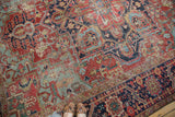 Distressed antique Heriz carpet showing cherry red field, light blue, and geometric vinery.