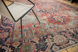 Distressed antique Heriz carpet with light blue spandrel and rich red field.