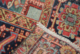Distressed antique Heriz carpet's folded corner, highlighting cherry red, navy patterns, and fringe.