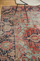 Distressed antique Heriz carpet, with faded red and light blue geometric pattern texture.
