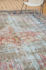 Textured distress of an antique Mahal carpet, revealing muted terra cotta and gold hues.