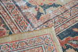 Antique Mahal carpet showing worn Persian pile in terra cotta, navy, gold, with woven backing.