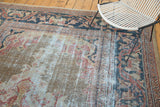 Heavily distressed texture on an antique Mahal carpet showing faded gold and teal.