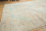 Distressed Sivas carpet showing blanched mint green corner spandrels and faded vinery on pale sand.