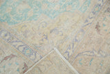 Distressed Sivas carpet corner showing faded mint green, saffron vinery, and hand-knotted backing.