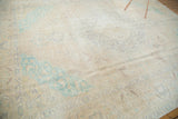 Softly distressed texture with blanched mint green and pale sand hues on a Sivas carpet.