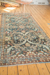 Distressed teal and terra cotta patterned border and fringe of a vintage Mahal runner.