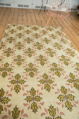 Detail of vintage Oushak rug with ivory field, saffron gold, blush quatrefoil pattern.