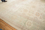 Pastel Sultanabad design rug featuring an ivory field, large floral elements, vinery, and soft abrashes.