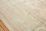 Soft pastel seafoam, ivory, and terracotta floral vinery on a Pakistani Sultanabad design carpet.