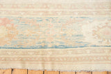 Pakistani Sultanabad carpet's pastel floral vinery, abrash, and patterned border with fringe.