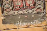 Tattered kilim end of the vintage Oushak rug, with geometric red, ivory, and taupe tones.