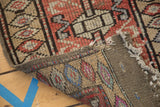 Vintage Oushak rug's hand-knotted foundation with visible tattered end and colorful pile.