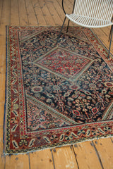 Textured corner of a distressed Mahal rug with brick red, indigo, and green henna lattice.