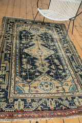 Distressed Malayer rug with navy blue rectilinear vinery and stylized bird motifs.