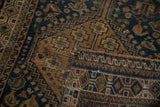 Distressed Qashqai rug's hand-knotted construction, tribal patterns, indigo and copper tones.