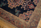 Distressed corner of antique Afshar rug, with teal mythological creature and madder red border.