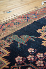 Unique stylized teal mythological creature on antique Afshar rug, madder red border.
