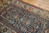 Distressed Baktiari rug detail; indigo field with textured geometric florals, madder root, and bronze.